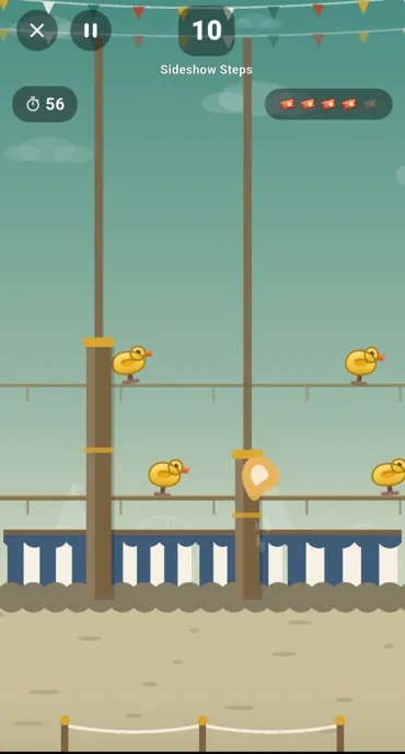 A stall in progress: the clock, the score, the five tickets, and ducks riding the belts behind the posts
