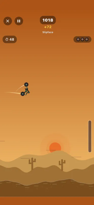 A backflip off a ramp, the bike turning over in the air above the dunes